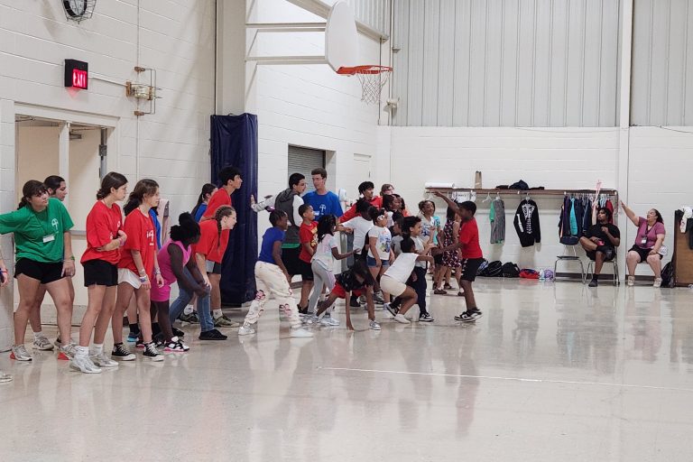 Children and youth volunteers participating in a relay race in a gym