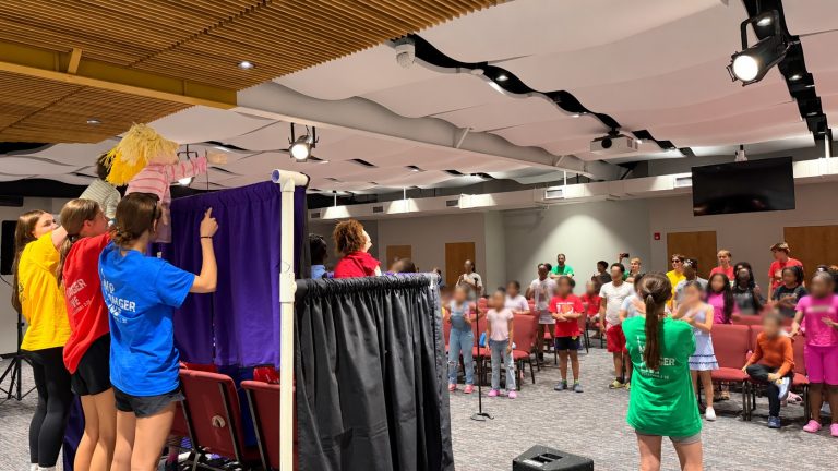 Children watching a puppet show gospel presentation