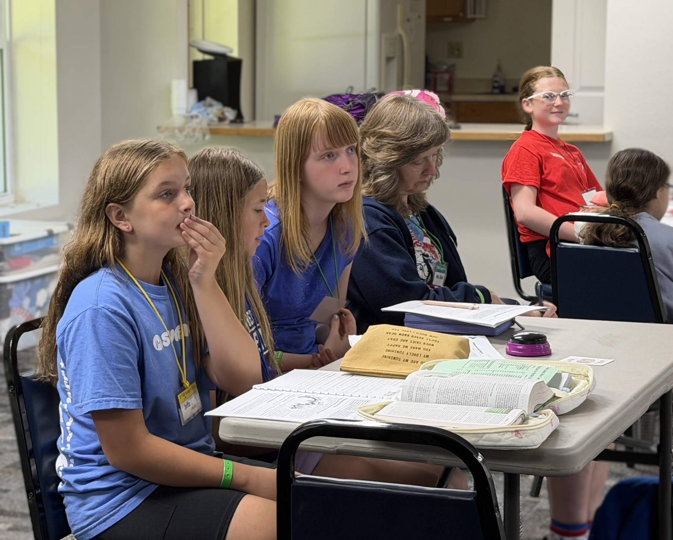 five girls and one leader listening intently at a girls' Bible study